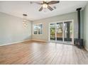 Bright living room features a ceiling fan, fireplace and sliding glass doors to the outside patio at 131 Pennsylvania Ave, Palm Harbor, FL 34683