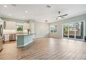 Open living space with modern light fixtures, sliding glass doors and wood look tile floors at 131 Pennsylvania Ave, Palm Harbor, FL 34683