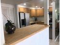 Kitchen with light wood cabinets, stainless steel appliances, and breakfast bar at 830 S Gulfview Blvd # 601, Clearwater Beach, FL 33767