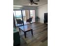Living room with balcony access, wood-look floors, and view of the water at 830 S Gulfview Blvd # 601, Clearwater Beach, FL 33767