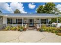 Inviting front porch with white railing and colorful potted plants at 4936 Mineola Pl, Palm Harbor, FL 34684
