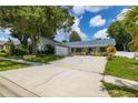 One-story home with a large driveway and well-maintained lawn at 4936 Mineola Pl, Palm Harbor, FL 34684