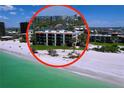 Beautiful beachfront condo building featuring private beach access and lush landscaping with palm trees at 7532 Bayshore Dr # 205, Treasure Island, FL 33706