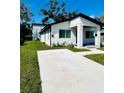 Contemporary home with a driveway and neatly maintained lawn at 1919 21St S St, St Petersburg, FL 33712