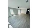 Spacious living area with grey wood-look flooring and a ceiling fan at 1919 21St S St, St Petersburg, FL 33712