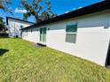 Rear view of a single-story home with sliding glass doors and a grassy yard at 1919 21St S St, St Petersburg, FL 33712