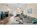 Spacious living room with sectional sofa, wood floors, and access to a balcony at 10823 Indian Hills Ct # 33, Seminole, FL 33777