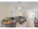 Comfortable living room with sectional sofa, wood floors, and a ceiling fan at 10823 Indian Hills Ct # 33, Seminole, FL 33777