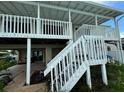 Elevated home with covered patio, stairs, and waterfront access at 15529 Redington Dr, Redington Beach, FL 33708