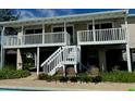 Back of house showing elevated deck, stairs, and pool area at 15529 Redington Dr, Redington Beach, FL 33708