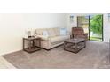 Living room featuring a beige sofa, recliner, and a coffee table at 1354 Azalea Dr # 1803, Dunedin, FL 34698