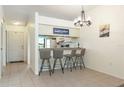 Kitchen with breakfast bar, light-colored cabinets, and neutral tile flooring at 1354 Azalea Dr # 1803, Dunedin, FL 34698