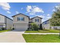 Two-story home with a two-car garage and landscaped front yard at 9309 Rally Spring Loop, Wesley Chapel, FL 33545