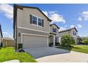 Two-story home with a two-car garage and landscaped front yard at 9309 Rally Spring Loop, Wesley Chapel, FL 33545