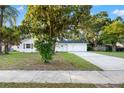 Inviting single-story home featuring a well-manicured lawn and mature trees, adding character to the property at 508 Brooker Rd, Brandon, FL 33511