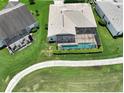 Aerial view showcasing house with pool and screened enclosure at 10312 Cleghorn Dr, San Antonio, FL 33576