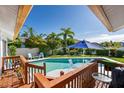 Inviting pool area with a deck and blue umbrella, perfect for outdoor entertaining at 366 6Th N Ave, Tierra Verde, FL 33715