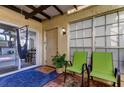 Relaxing patio with two green chairs, a hammock, and view into the home at 7200 Ulmerton Rd # F2, Largo, FL 33771