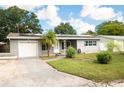 Gray house with solar panels, white garage door, and landscaped lawn at 5575 6Th N Ave, St Petersburg, FL 33710