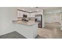 Modern kitchen with white cabinets and stainless steel appliances at 5552 Logan Cave Ave, Wimauma, FL 33598