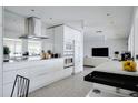 Sleek white kitchen featuring modern appliances and an open layout to the living area at 440 64Th Ave, St Pete Beach, FL 33706