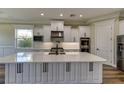 Modern kitchen with white cabinets, large island, and stainless steel appliances at 241 5Th N Ave, Safety Harbor, FL 34695