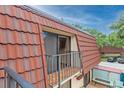 Private balcony with a red tile roof and a view of the parking lot at 707 1St Ct, Palm Harbor, FL 34684