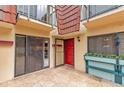Townhouse patio with red door, sliding glass doors, and planter boxes at 707 1St Ct, Palm Harbor, FL 34684