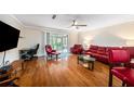 Living room with hardwood floors, red leather furniture, and access to a patio at 3455 41St S Ter # 208, St Petersburg, FL 33711