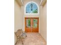 Inviting entryway with double doors and arched window at 1950 Lillian Ave, Tarpon Springs, FL 34689