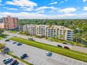 Exterior view of condo building with rows of balconies, parking lot, and tree-lined street at 1200 N Shore Ne Dr # 301, St Petersburg, FL 33701