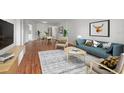 Stylishly furnished living room with blue couch, unique rug, dining area, and modern decor at 1200 N Shore Ne Dr # 301, St Petersburg, FL 33701