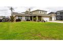Two-story house with a large green lawn at 22607 Southshore Dr, Land O Lakes, FL 34639