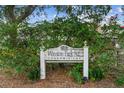 Winston Park N.E. Condominium sign surrounded by lush greenery with glimpses of pink flowers at 5095 Bay Ne St # 114, St Petersburg, FL 33703