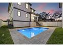 Inviting backyard pool with patio, and stylish two-story home at dusk at 135 48Th Ave, St Petersburg, FL 33703