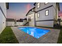 Inviting backyard pool with patio, lounge chairs, and stylish two-story home at dusk at 135 48Th Ave, St Petersburg, FL 33703