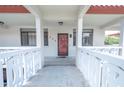 Condo building entry with red door and balcony at 2612 Pearce Dr # 306, Clearwater, FL 33764