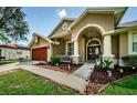 Welcoming one-story house featuring an arched entryway and manicured lawn at 957 Westwinds Blvd, Tarpon Springs, FL 34689