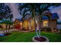 Attractive one-story house with well-maintained landscaping at night at 957 Westwinds Blvd, Tarpon Springs, FL 34689