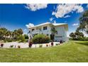 Two-story home with white exterior, landscaping, and a paved driveway at 13064 Via Flavia, Placida, FL 33946