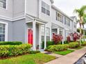 Row of townhouses with red doors and landscaping at 2745 Enterprise E Rd # 24, Clearwater, FL 33759