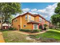 Condominium building with orange and red trim, well maintained landscaping and blue skies at 2272 Chianti Pl # 4-0048, Palm Harbor, FL 34683