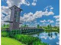 Scenic view of the wooden Union Park bridge over a pond with a wooden tower and lush landscaping at 31980 Goddard Dr, Wesley Chapel, FL 33543