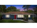 Cute house with red door, blue exterior, and a nicely landscaped yard at 5425 Waters Edge Dr, New Port Richey, FL 34653
