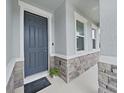 Front entry with gray door and stone accents at 31980 Goddard Dr, Wesley Chapel, FL 33543