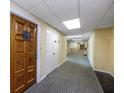 Building hallway with wood door and carpeted floor at 420 64Th Ave # A, St Pete Beach, FL 33706