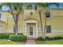 Condo building entrance with yellow facade and lush landscaping at 5257 Beach Se Dr # D, St Petersburg, FL 33705