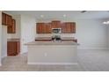 Kitchen with wood cabinets, double sink, and an island at 16716 Scenic Hill Way, Wimauma, FL 33598