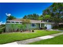 Landscaped front yard of a beautiful house with manicured lawn at 10799 Harborside Dr, Largo, FL 33773