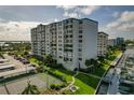 Multi-story condo building with manicured grounds, tennis court, and marina access at 660 Island Way # 301, Clearwater Beach, FL 33767
